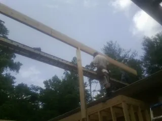 Carpenter setting a ridge beam over a new addition frame — Ice Dam Removal by Roofing Brothers in Mascot
